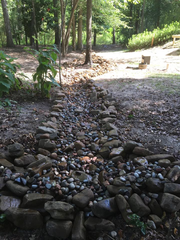 dry creek bed with colorado stone and arkansas boulders for erosion control 