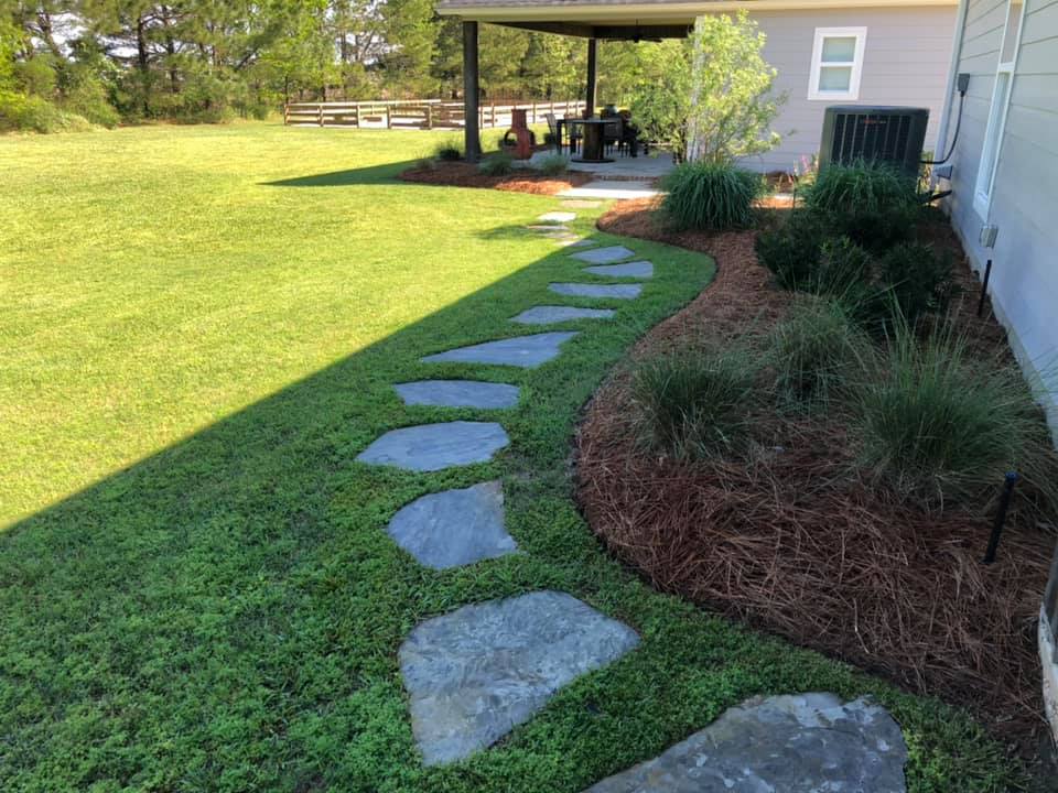 large flagstone surrounded by lush sod and well defined bedlines