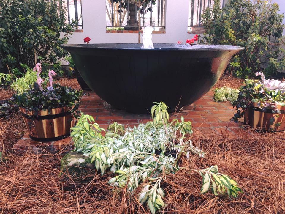 Old fashioned sugar kettle fountain with cedar planter accents